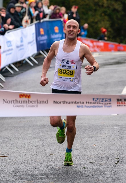 A man running, approaching the finish line.