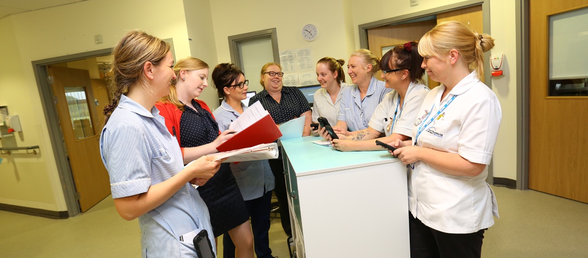 Group of healthcare staff having a discussion while standing.