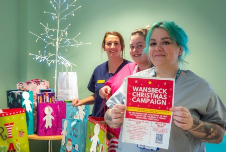 Three woman standing with some Christmas presents.