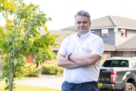 Portrait of a male standing with his arms folded.