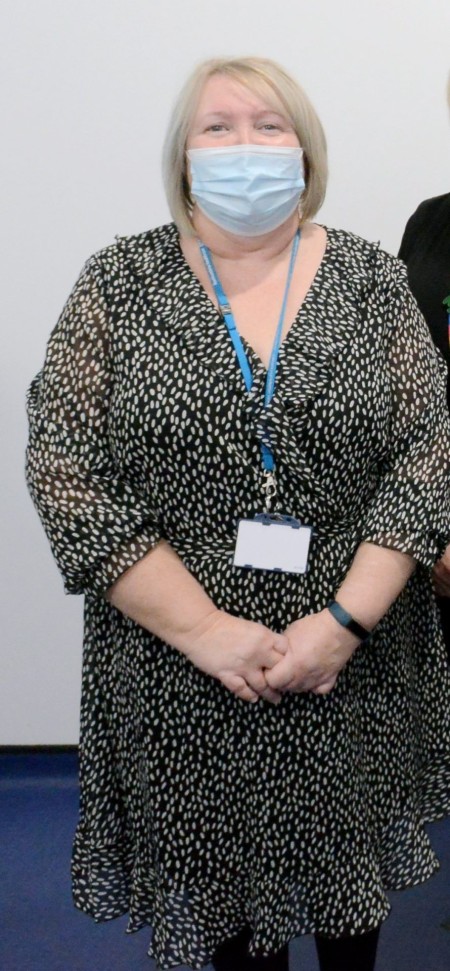 A woman with short blonde hair wearing a black and white dress.