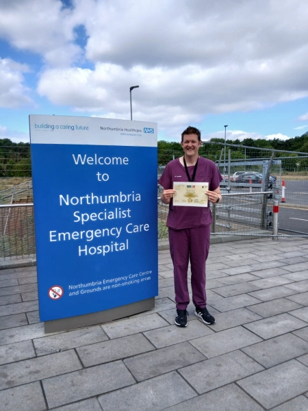 James Walton, emergency department consultant, holding the gold accreditation certificate