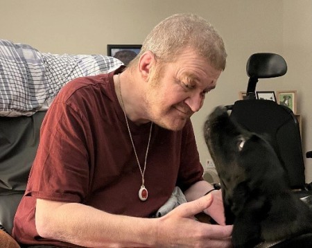 A man sitting with a dog.