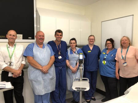 A group of people wearing scrubs and aprons.