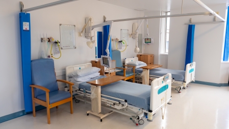 An empty ward with hospital beds.