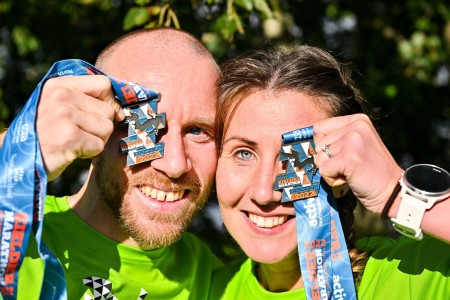 A man and a woman holding up medals.