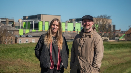 Nic and Colin standing in front of the construction of the new Berwick hospital