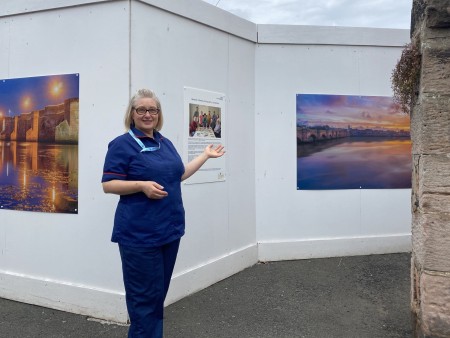 A woman standing infront of some artwork