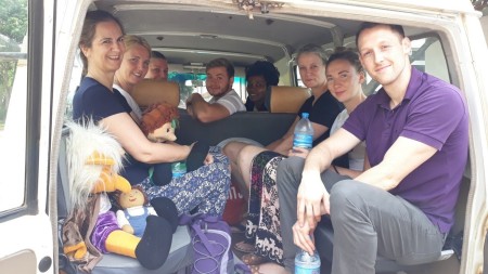 A group of people sat in the back of a minibus.