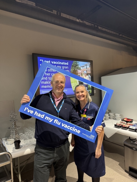 Two people holding a selfie frame promoting vaccinations.