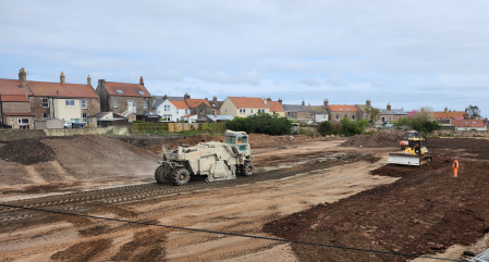 A construction site with two construction vehicles.