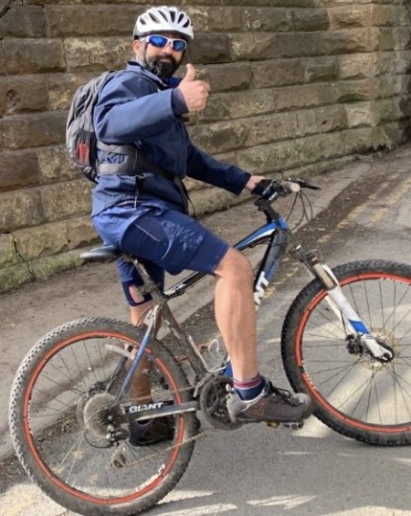 A man on a boke giving a thumbs up to the camera.