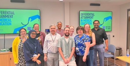 A group of people in a room smiling at the camera.