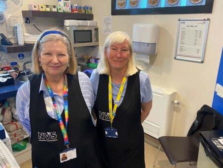 Two women wearing NVS aprons smiling at the camera