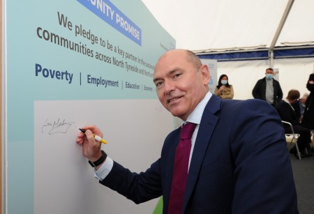 A man signing a board.