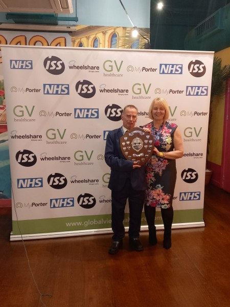 A man holding an award, standing next to a woman.