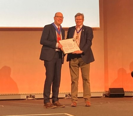 A man being presented with an award