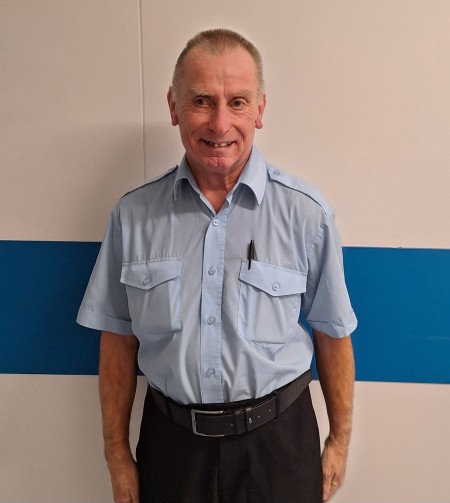 Man in blue uniform shirt smiling 