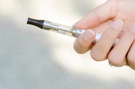 A close up of a hand holding an E-Cigarette 