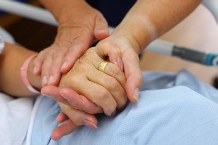 A close up image of two people holding hands.