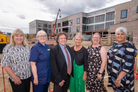 A group of six people standing in front of a construction site.