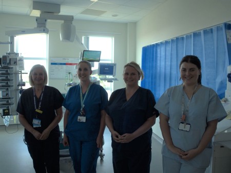 A photograph of four women wearing scrubs.