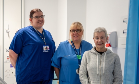 3 people stood looking at the camera - 2 staff and 1 patient
