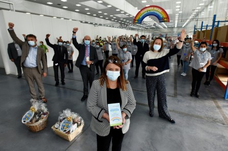 A large group of people standing in a factory.