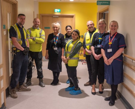 A group of people, some of them are wearing hi-vis vests.