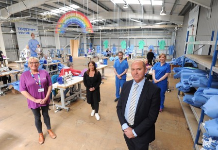 A group of people standing in a textiles factory.