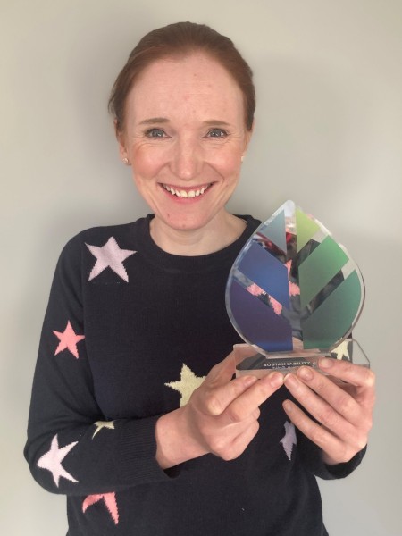 A portrait of a woman holding an award.