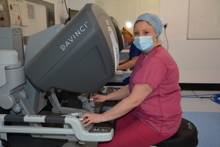 Woman in pink scrubs operating the robot