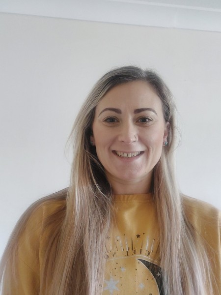 A woman with long blonde hair smiling.