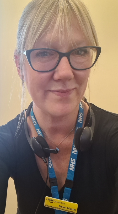Lady with blonde hair wearing glasses and smiling to the camera 