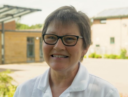 Image of woman with short brown hair and glasses smiling 