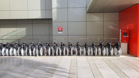 A photograph of a group of wheelchairs lined up next to each other.
