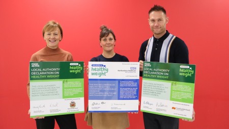 Three people holding boards with declarations on them.