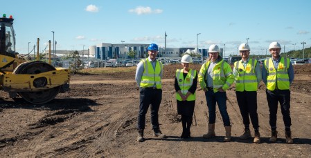 Five people wearing hi-vis jackets and helmets.