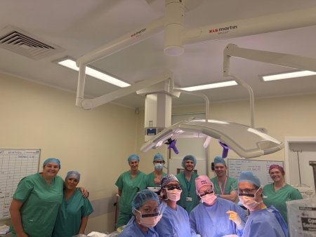 A group of surgeons standing in a theatre room.