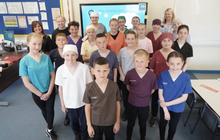 A group of children wearing scrubs.