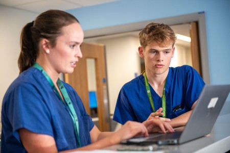 Image shows two consultants reviewing patient list